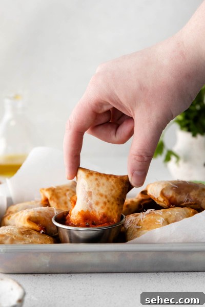 Crispy Air Fryer Pizza Rolls Recipe 9 fingers picking up air fryer pizza rolls