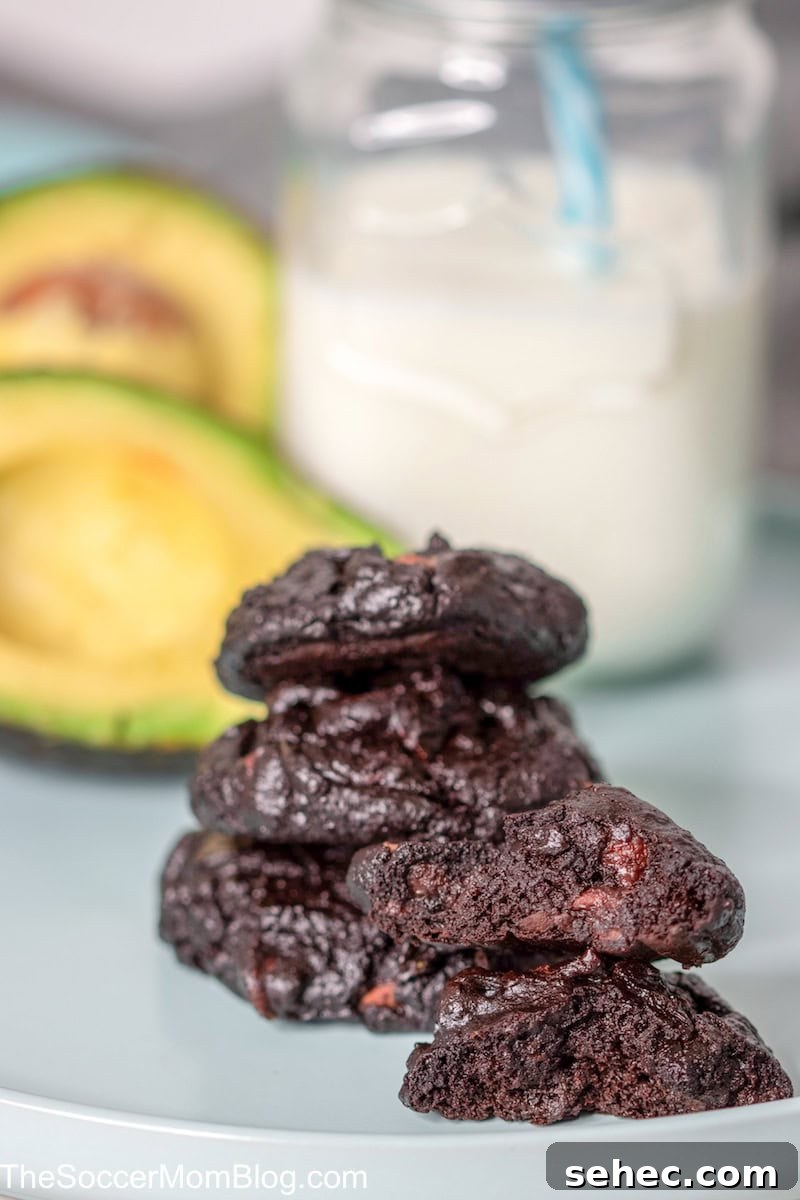 Fudgy Chocolate Avocado Cookies 2 stack of chocolate cookies with milk and avocados.
