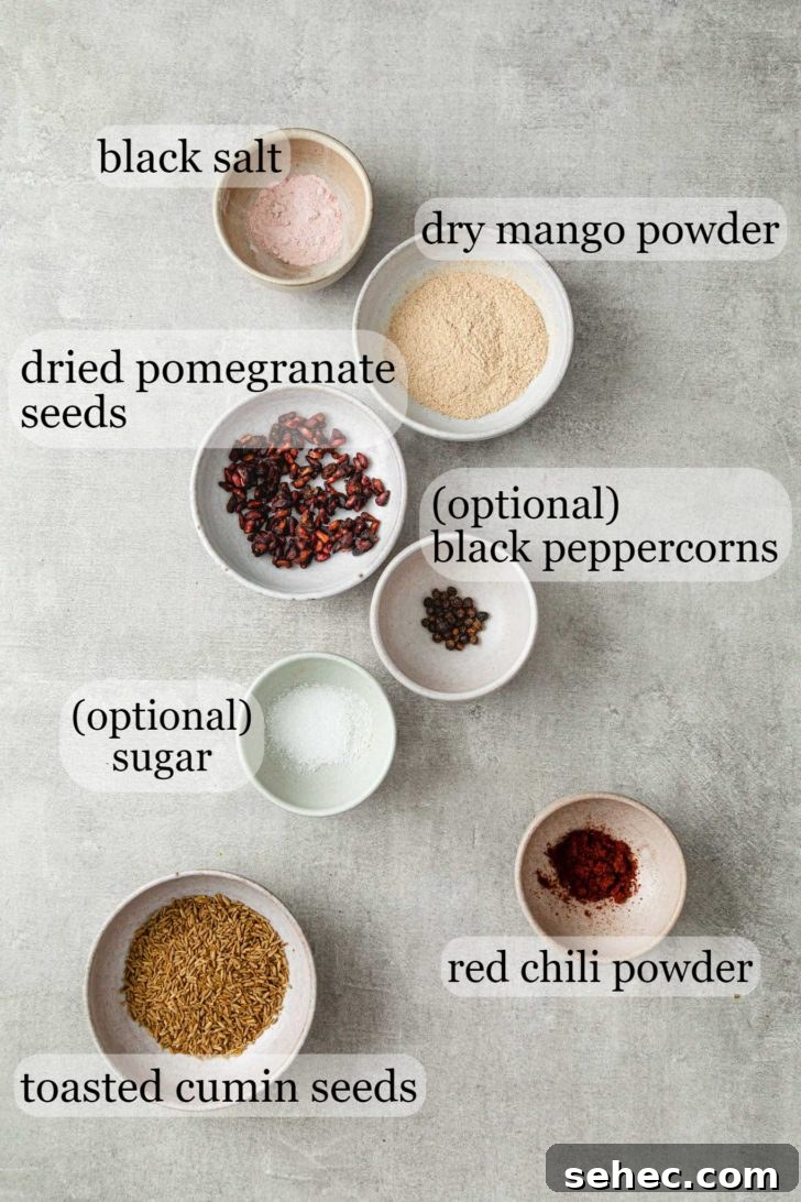 Authentic Chaat Masala Recipe: Homemade Indian Spice Mix 4 A grey surface with bowls containing the ingredients for chaat masala