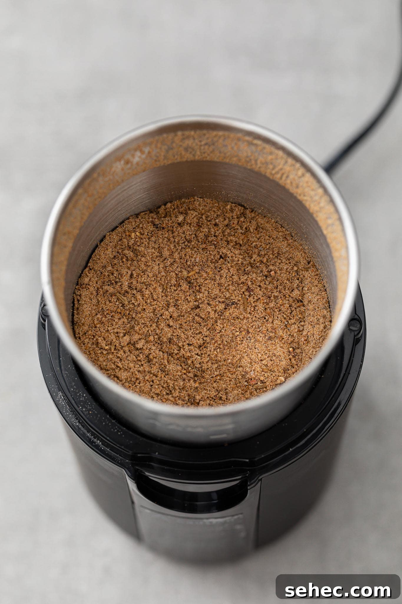 Authentic Chaat Masala Recipe: Homemade Indian Spice Mix 8 Ground chaat masala in a spice grinder ready to be stored