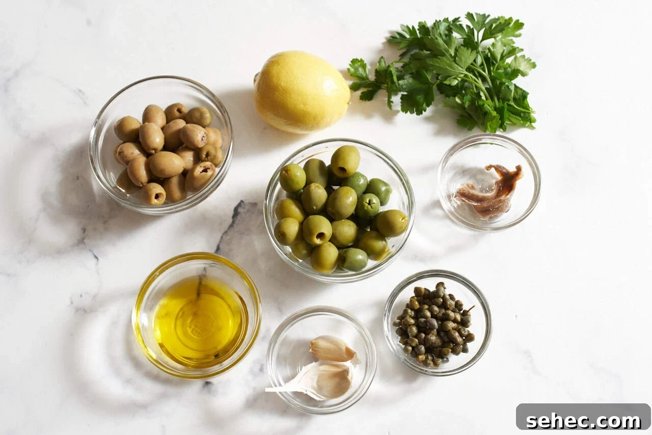 Homemade Green Olive Tapenade Recipe 3 A lemon, some fresh parsley, and small bowls of anchovies, capers, garlic cloves, green olives, and olive oil.
