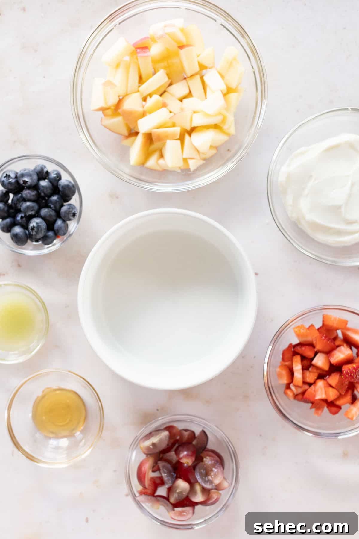 Assorted ingredients for creamy fruit salad.