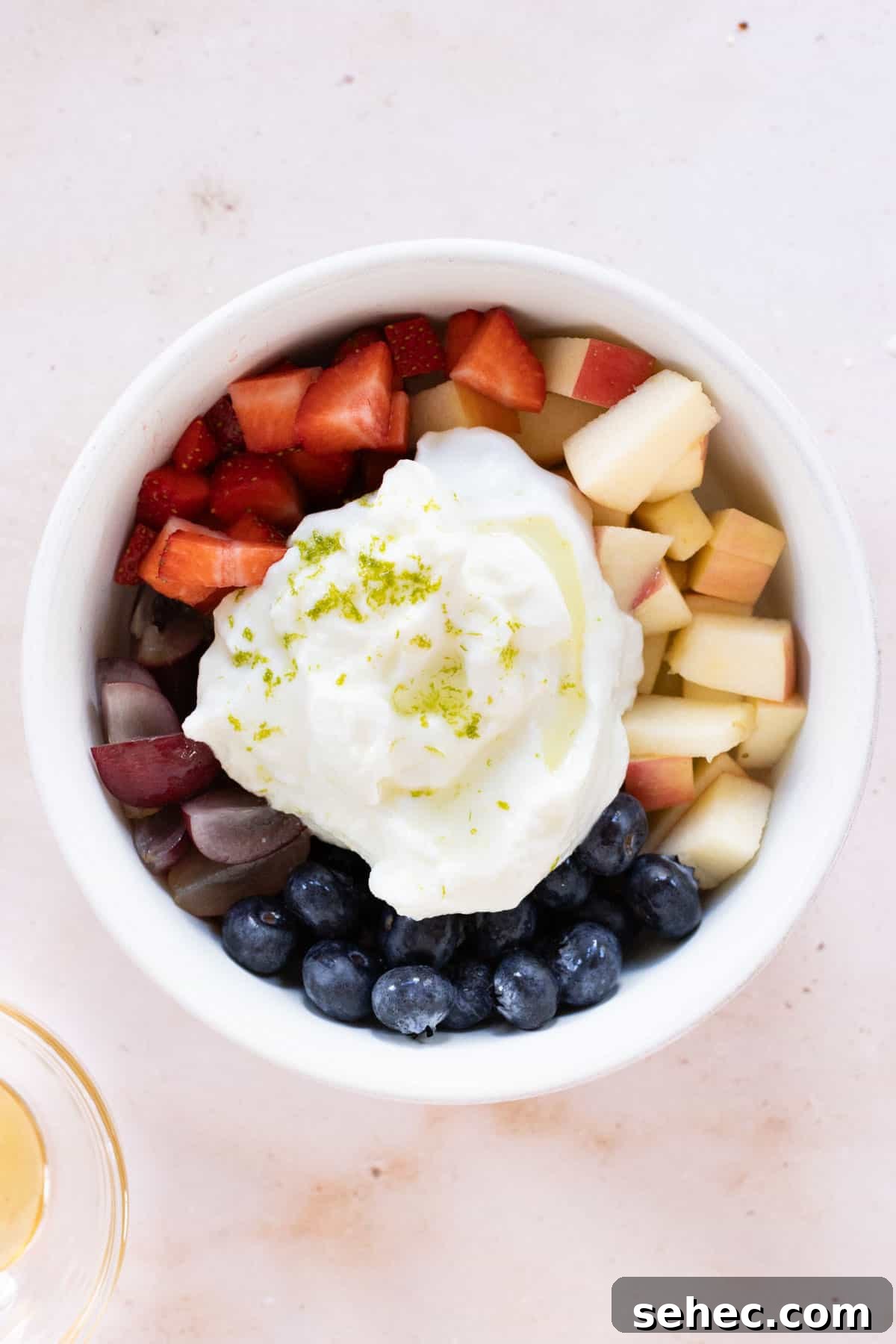 A bowl full of fruit and yogurt with lime zest.