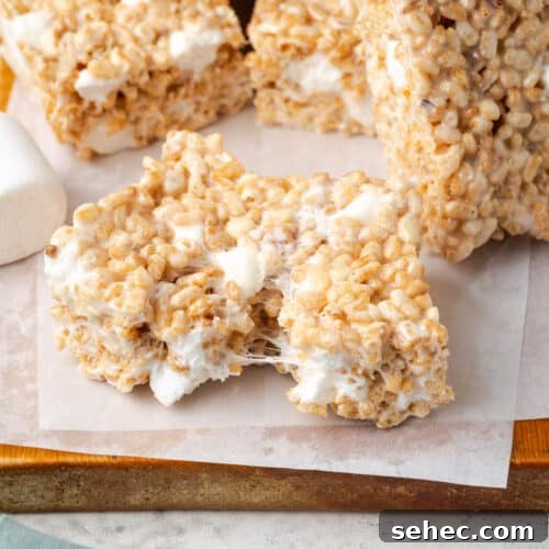 A gluten free rice krispie treat being broken in half.