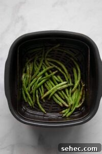 Crispy Air Fryer Green Beans: 4 Flavorful Recipes 12 crispy green beans in air fryer basket