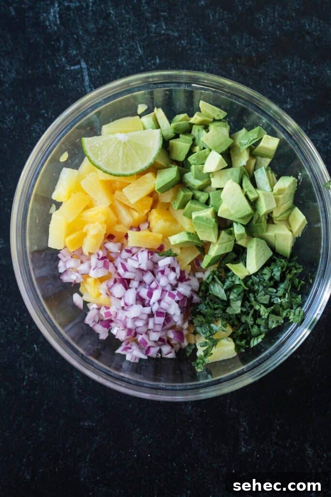 Fresh Pineapple and Avocado Salsa with Lime 4 Diced ingredients arranged in a mixing bowl.
