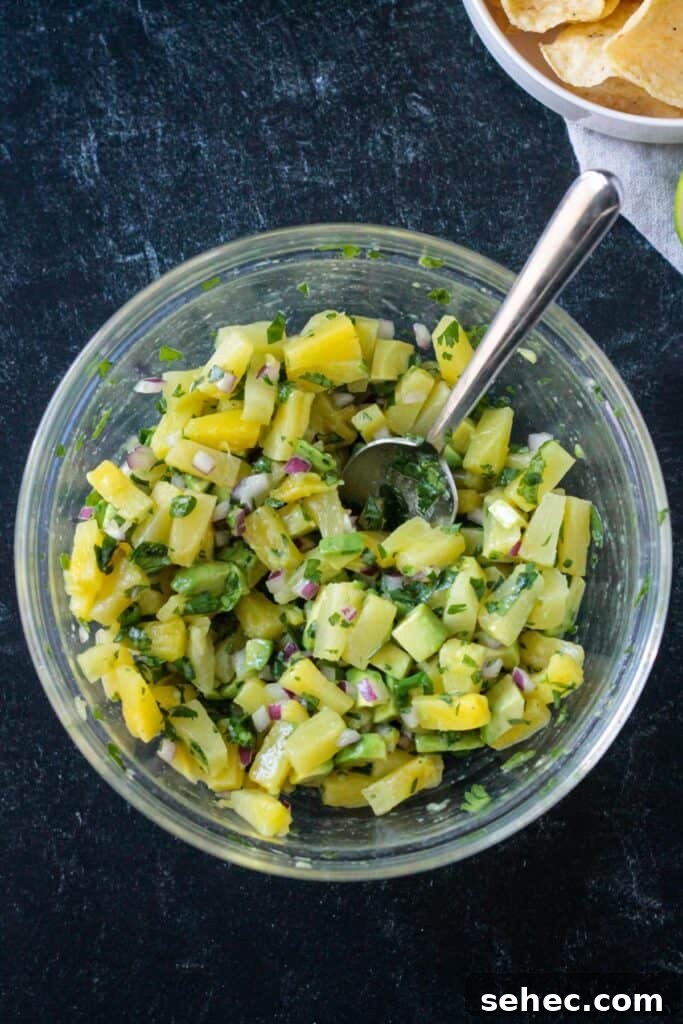 Fresh Pineapple and Avocado Salsa with Lime 5 Diced pineapple, avocado, cilantro, and red onion mixed in a bowl.