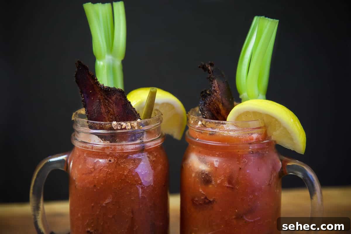 Smoked Bloody Marys garnished with Smoked Bacon, lemon wedge and celery.