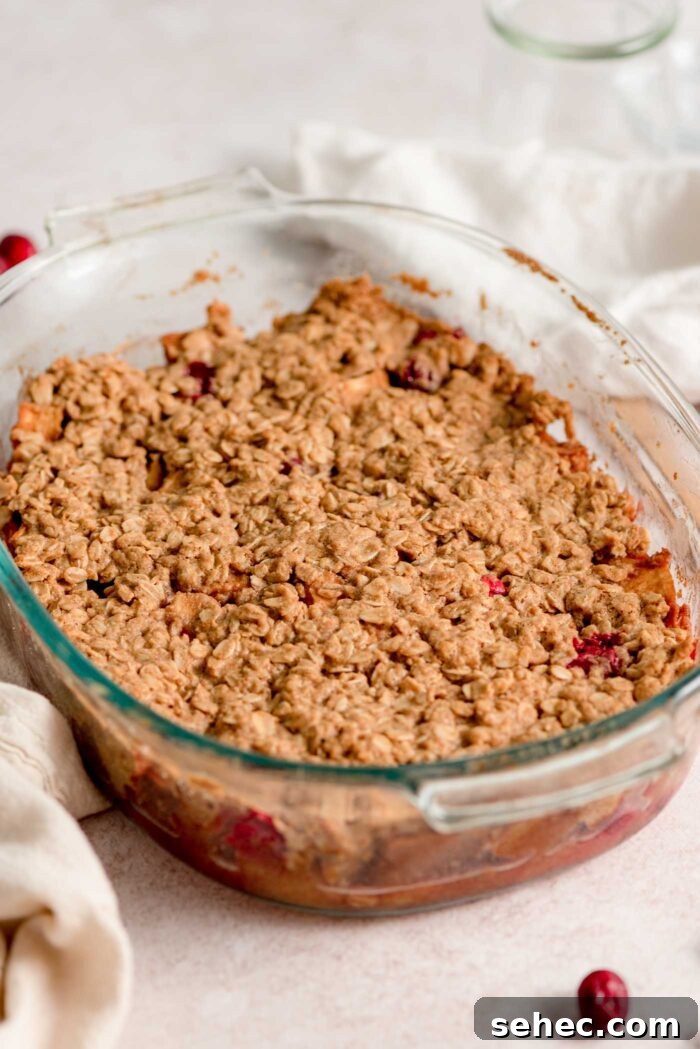 A baked cranberry apple crisp in an oval glass baking dish.