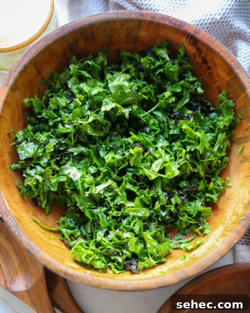 Zesty Crunch Rainbow Slaw Recipe with Colorful Veggies 4 overhead view of a wooden bowl of massaged kale.