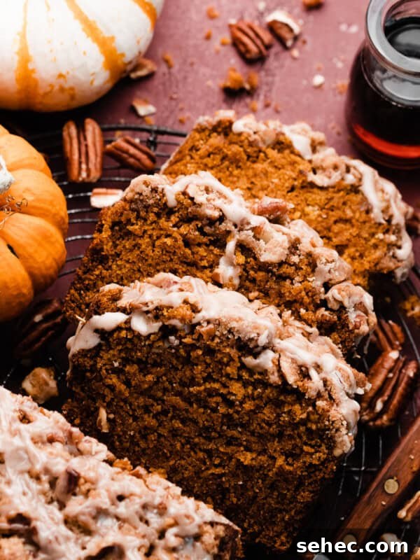 Slices of the pumpkin bread on a vintage cooling rack topped with pecan streusel and maple glaze.