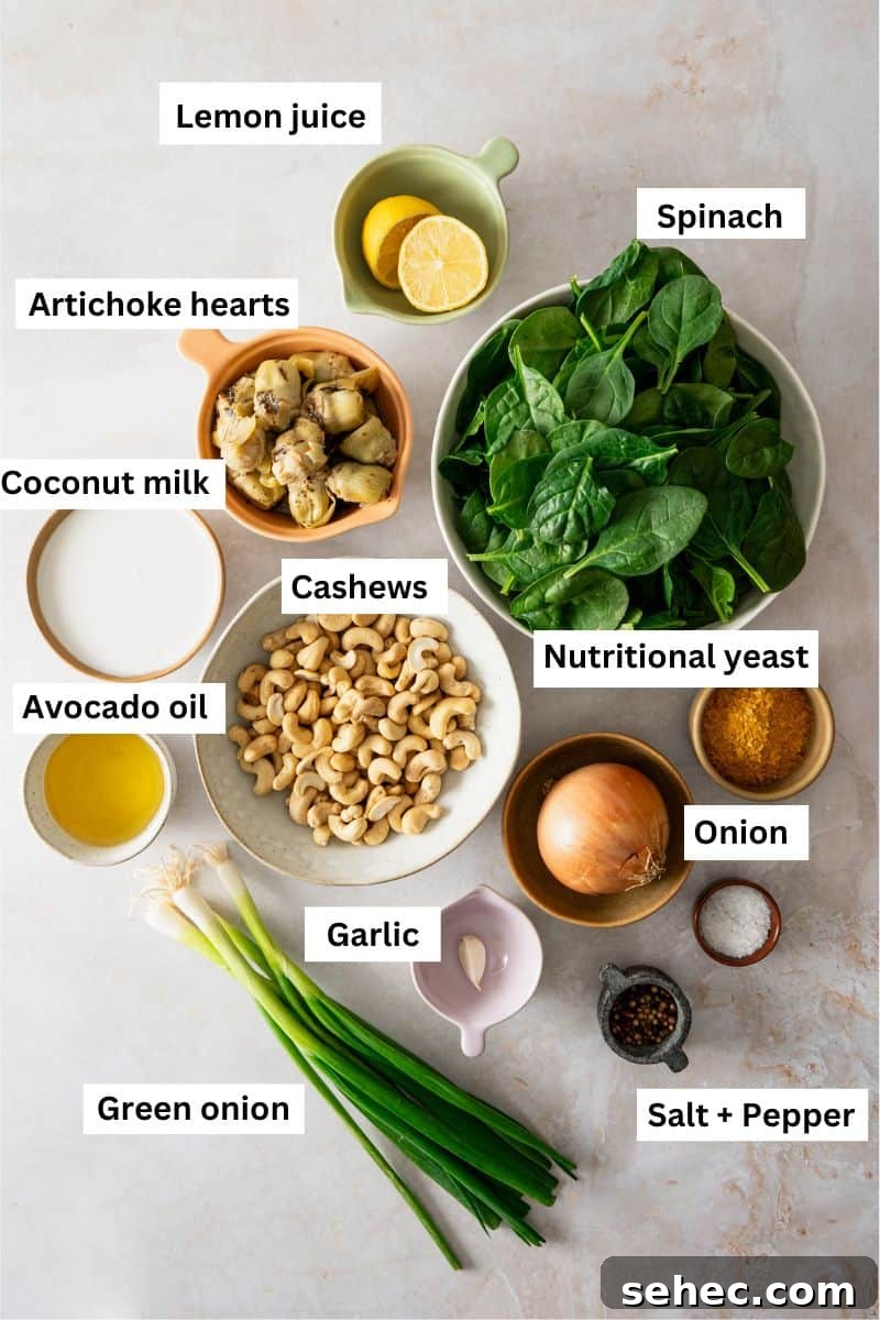 Ingredients in different bowls including spinach, onion, artichoke hearts, cashews, nutritional yeast and lemon wedges.