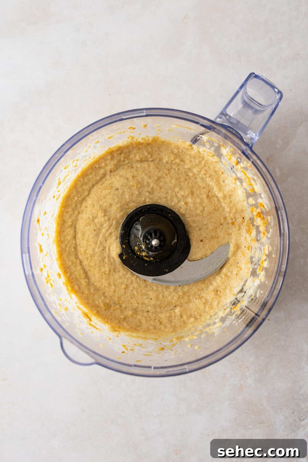 A blender with a creamy white sauce in it.
