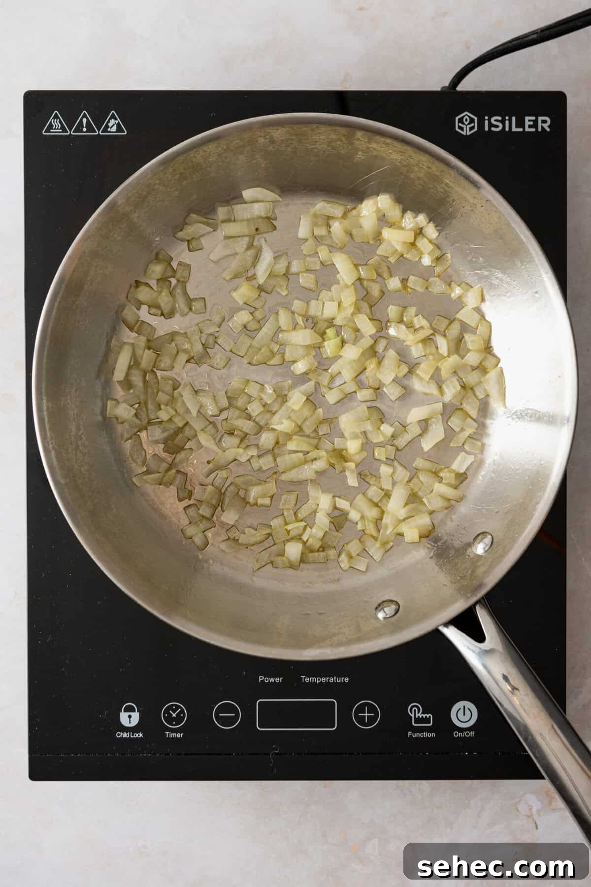A pan with chopped onion cooking in it.